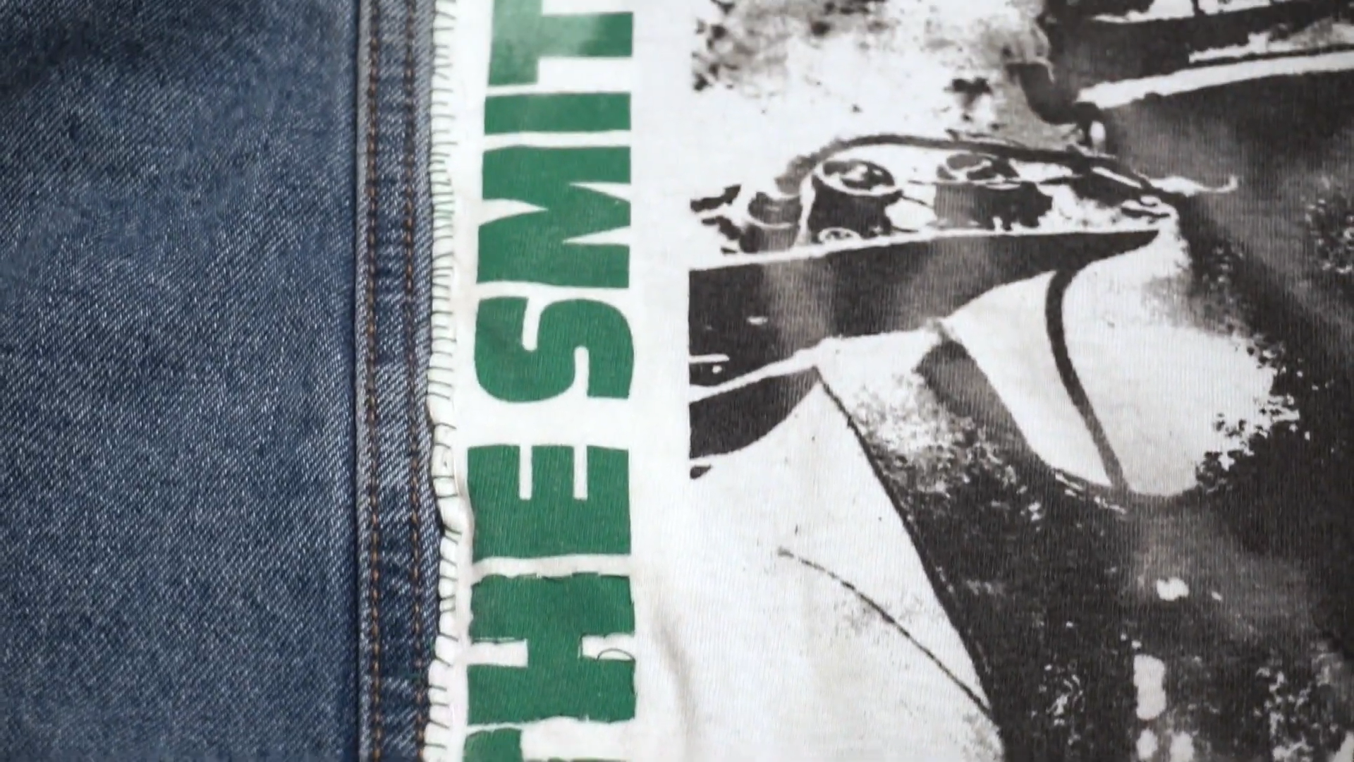 extreme close-up photo showing the green whip stitch looping over the edge of the white fabric and into the blue denim.png