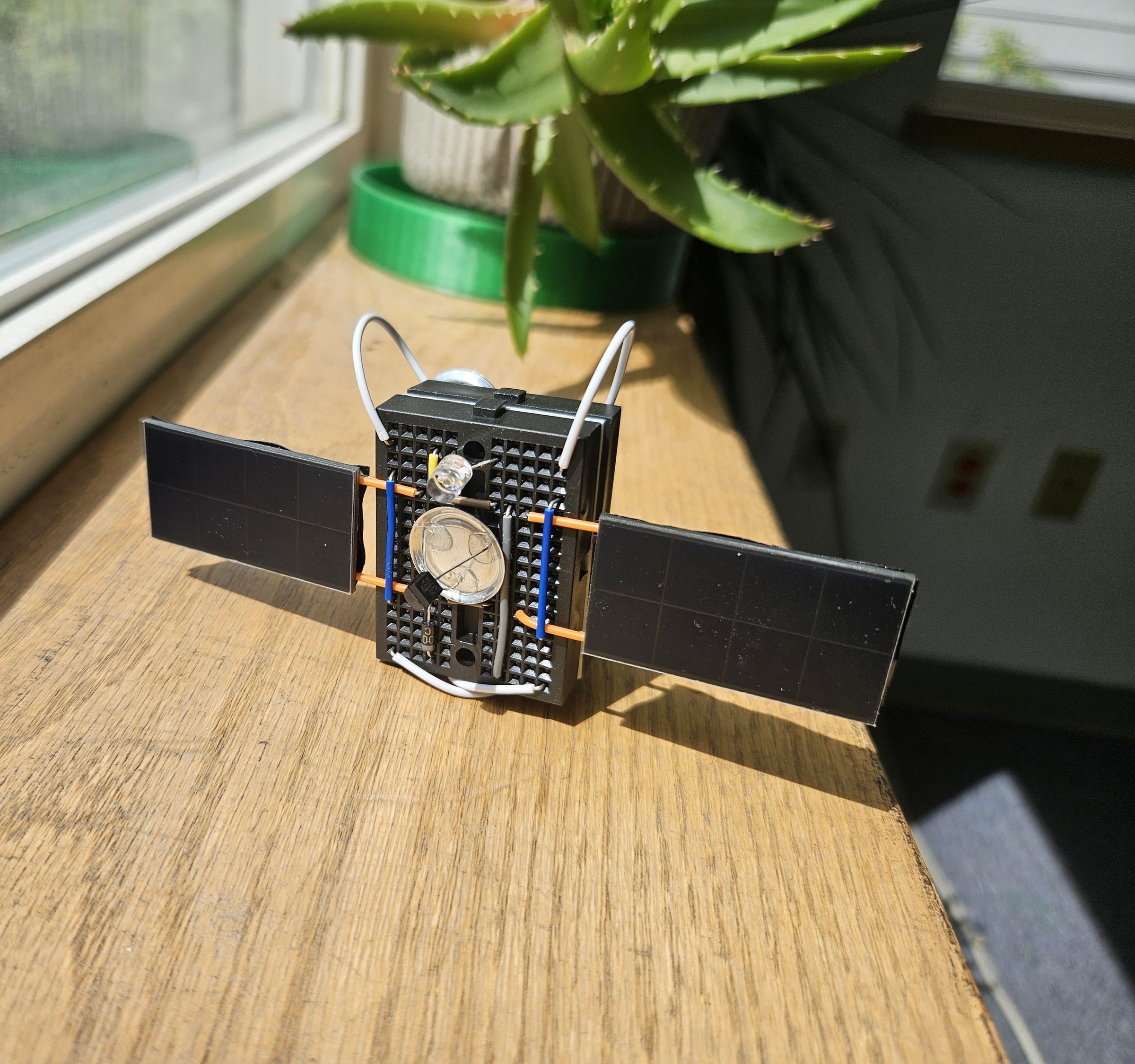BreadSat (satellite-looking, solar-powered blinking LED circuit on breadboards)